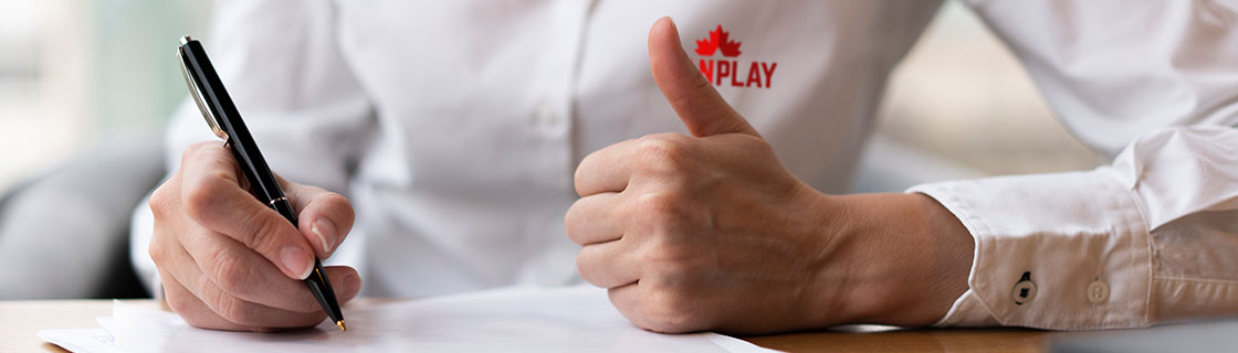 Man signing a contract wearing a CanPlay shirt.
